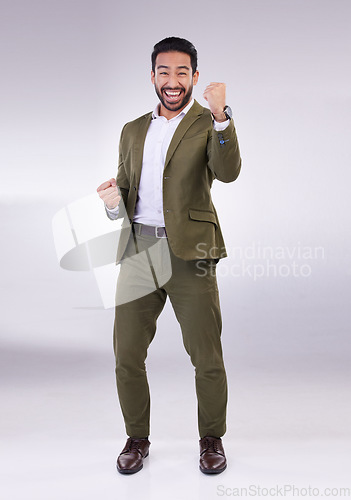 Image of Business man, fist pump and celebrate success or winning portrait in studio on a gray background. Asian male entrepreneur with hands to cheer as winner for growth, bonus or finance profit achievement