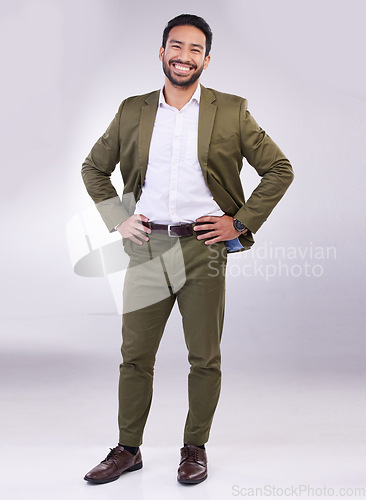 Image of Portrait, smile and a business man in studio standing hands on hips against a gray background feeling confident. Success, motivation and vision with a happy male employee looking proud or positive