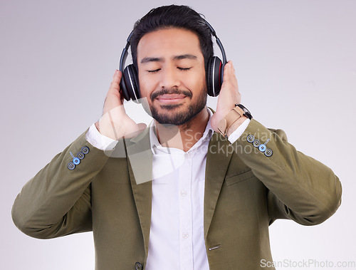 Image of Music, relax and headphones with a business man in studio on a gray background streaming audio. Peace, quiet and calm with a male employee listening to the radio during a mental health break