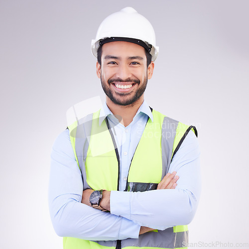 Image of Construction worker in portrait, man with crossed arms and smile, architect or engineer in building industry on studio background. Happy male contractor, mockup and professional builder with helmet