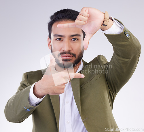 Image of Finger framing, portrait and business man in studio, background or capture profile picture. Face of male model, hands and frame perspective for selfie, photography ideas or imagine border of planning