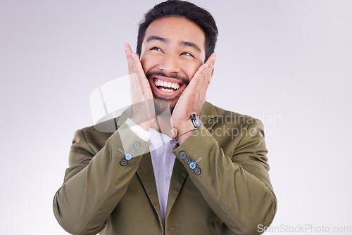 Image of Excited, thinking and Asian man with smile, success and profit growth against a grey studio background. Japan, male employee and entrepreneur with hands on face, winner and victory with happiness