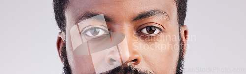 Image of Black man, eyes and face portrait in studio for vision, focus and serious expression to stare. African male person on a grey background for eyesight, determination and awareness of unique identity