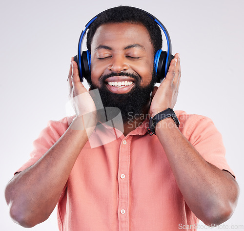 Image of Black man, studio and headphones for streaming music to relax, listen and free mindset by background. Happy african model, audio and sound for peace, mindfulness and online podcast with smile on face