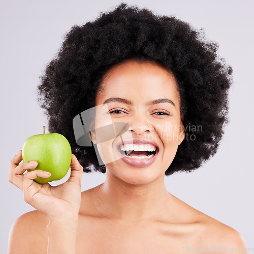 Image of Portrait, health and black woman with apple, diet and happiness against a grey studio background. Face, African American female and lady with fruit, wellness and healthy lifestyle with smile and joy