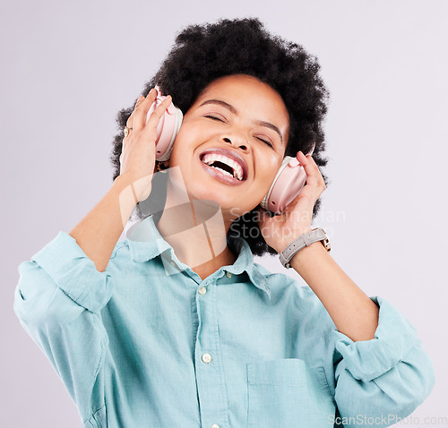 Image of Music headphones, dance and happy black woman streaming song for studio fun, freedom and wellness. Dancing energy, audio podcast and person listening to radio, media sound or track on gray background