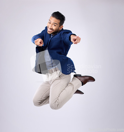 Image of Jump, excited and portrait of man point in studio with surprise, happiness and celebration on white background. Winner, success mockup and isolated happy male jumping with energy, smile and victory