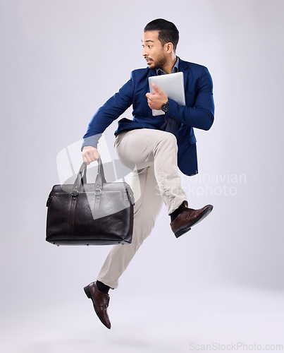 Image of Late, work and an Asian man jump for business isolated on a white background in a studio. Fast, serious and a corporate Japanese businessman running in the air while rushing to the workplace