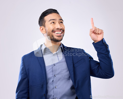 Image of Asian man, business and pointing hand at space in studio for motivation and advertising. Happy model isolated on gray background as corporate professional and finger for mockup promotion announcement