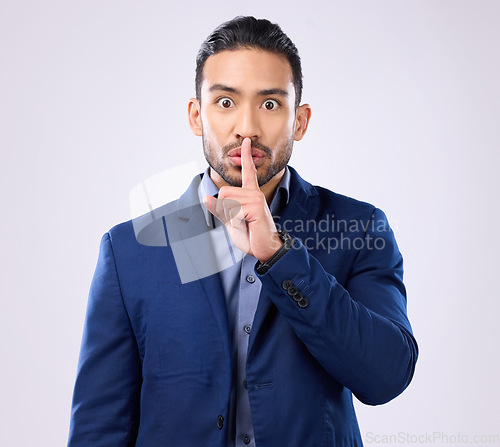 Image of Portrait, corporate man and finger on lips in studio, background and privacy secret. Male employee, silence hands and quiet mouth for shush sign, gossip or whisper in silent emoji of business mystery