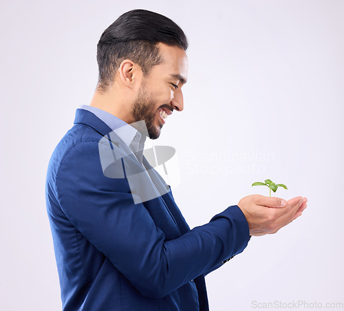 Image of Happy man, plant in hands and business growth isolated on a white background in eco friendly investment. Asian person with sapling soil in palm for sustainable startup and green investing in studio