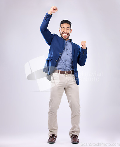 Image of Celebration, excited and portrait of man with fist in air for, happiness, success and bonus on white background. Winner, smile and isolated happy male in studio celebrate winning, good news and deal