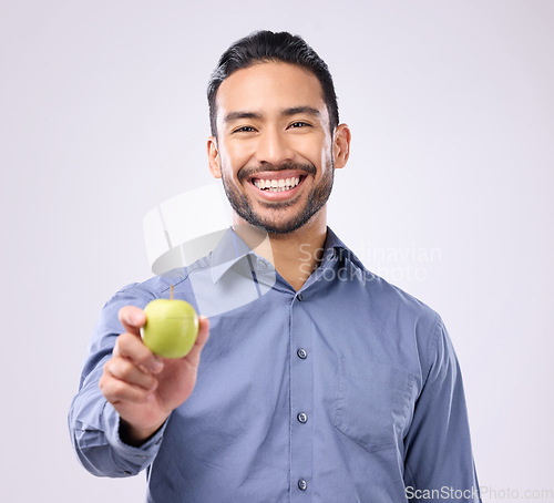 Image of Apple, portrait and man happy with fruit for weight loss diet, studio healthcare or body detox. Wellness food, nutritionist lifestyle person and male vegan giving product isolated on gray background