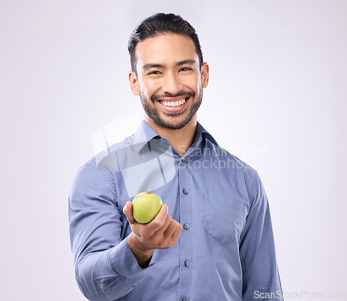 Image of Apple, studio portrait and man happy with product for weight loss diet, healthcare lifestyle or body detox. Wellness food, nutritionist person and male vegan giving fruit isolated on gray background