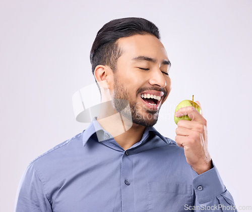 Image of Hungry, eating and an Asian man with an apple isolated on a white background in a studio. Health, food and a Japanese male with fruit for nutrition, diet or hunger during lunch on a backdrop