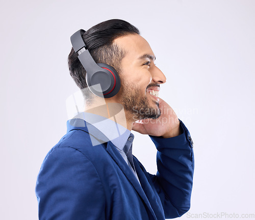 Image of Business, happy man and thinking with music headphones, studio or background of happiness. Smile, young worker and listening to radio, sound and corporate podcast of audio, motivation and inspiration
