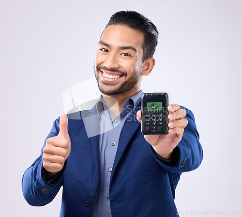 Image of Business man, pos and studio portrait with thumbs up, fintech tick and payment security by grey background. Asian entrepreneur, sales expert and machine for purchase, buying and approve with success