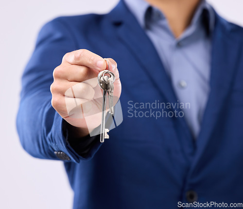 Image of Realtor, keys and studio closeup of hands for man, new home or property by gray background. Businessman, real estate agent and entrepreneur for buying building, apartment and goals with key at job