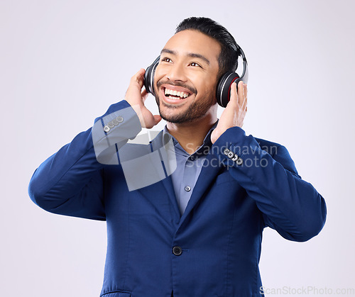 Image of Executive man, music headphones and thinking on studio background of happiness, motivation and inspiration. Happy corporate worker listening to audio, sound and business podcast on radio with smile