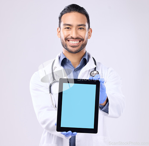 Image of Tablet, green screen and doctor portrait isolated on a white background technology for telehealth service mockup. Medical professional or healthcare asian man with digital app mock up space in studio