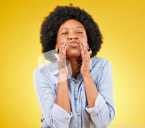 Image of Happy, blow kiss and black woman in a studio for love, romance or flirting face gesture. Happiness, sensual and African female model with a romantic kissing facial expression by a yellow background.