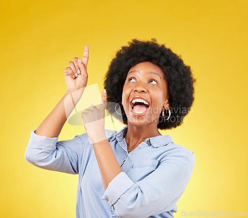 Image of Studio promotion, excited and black woman point up at mock up space, advertising mockup or marketing promo. Commercial girl, gesture and happy person with product placement deal on yellow background