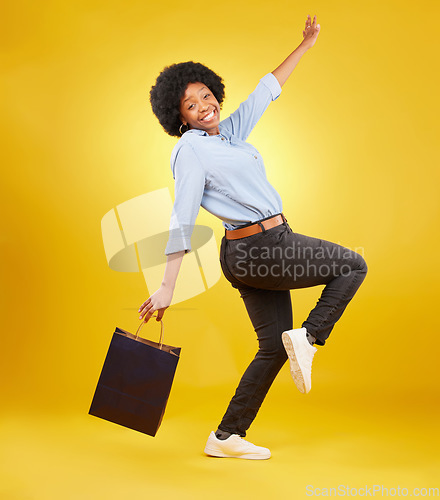 Image of Bag, portrait and happy black woman shopping, excited and celebrating sale in studio on yellow background. Face, shopper and girl customer cheerful after boutique, retail or store discount isolated