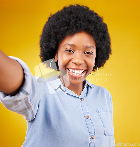 Image of Portrait, selfie and black woman in studio happy, smile and confident against yellow background. Face, social media and girl influencer posing for photo, profile picture or blog update or vlog post