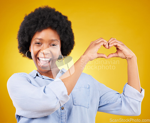 Image of Love, heart hands and portrait of black woman, smile and kindness isolated on yellow background. Motivation, support and loving hand gesture, like sign or emoji, happy African model in studio mockup.