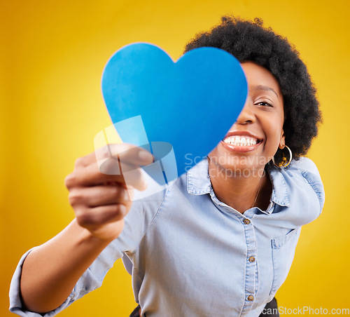 Image of Paper, heart and happy with black woman in studio for romance, positive and emotion. Happiness, love shape and giving with female isolated on yellow background for date, feelings and affectionate