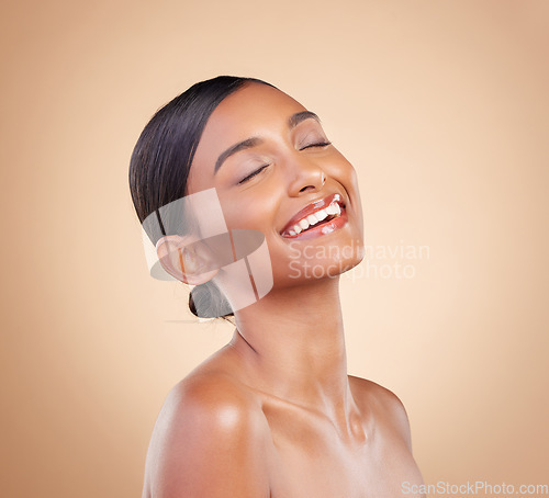 Image of Woman, smile and face in beauty skincare cosmetics or makeup against a studio background. Happy relaxed female model smiling in happiness and satisfaction for perfect skin, self love or facial care
