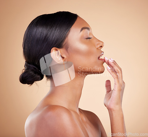 Image of Touching lip, skincare and black woman with dermatology, beauty and organic facial on brown studio background. African American female, hand on mouth and lady with cosmetics, self love and soft skin