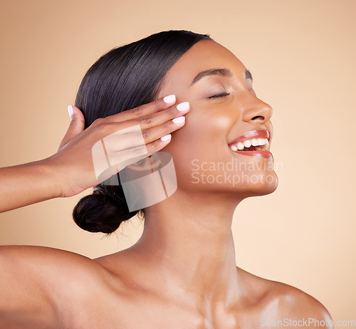 Image of Beauty, hands on face and skin of a woman in studio for skincare, dermatology and cosmetics. Happy Indian female model with smile and self care facial glow or shine profile on brown background