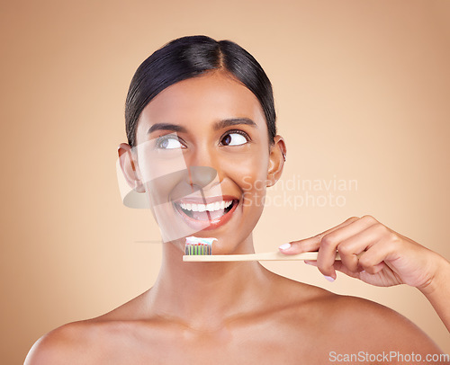 Image of Woman, thinking and bamboo toothbrush for dental care, teeth or healthcare and skincare against a studio background. Happy female smile with tooth paste for healthy clean oral, mouth or gum hygiene