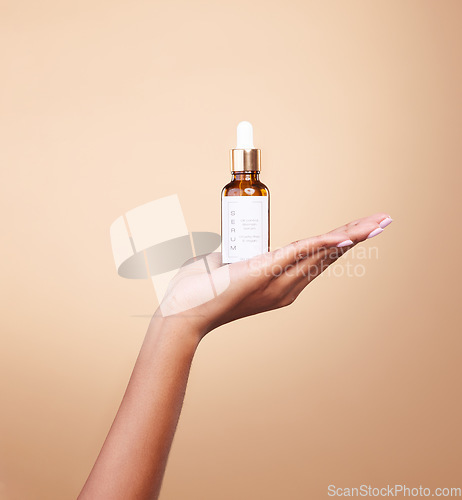 Image of Hand, product and antiaging serum with a woman in studio on a beige background to promote skincare. Marketing, advertising and luxury with a female holding a bottle for the promotion of beauty