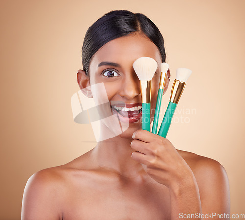 Image of Girl, brushes or makeup artist with beauty, facial products or luxury self care on studio background. Wow, happy model face or excited young Indian woman with cosmetics, glowing skincare or smile