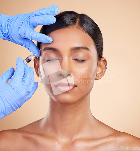 Image of Studio, face lift or Indian woman with injection for beauty, plastic surgery or medical cosmetics. Skincare, dermatology or hands with needle in filler facial treatment on young girl with eyes closed