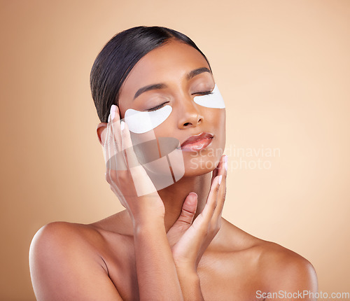 Image of Face, beauty or girl with eye patch for skincare or wellness isolated on studio background. Cosmetics or Indian woman with facial collagen pads or dermatology product for anti aging or dark circles