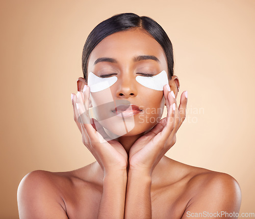 Image of Face, beauty or Indian woman with eye patch for skincare or wellness isolated on studio background. Cosmetics or girl model with facial collagen pads or dermatology product for anti aging or glow