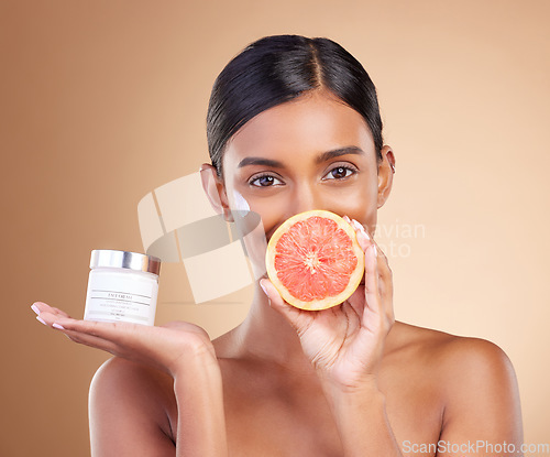 Image of Grapefruit, portrait or happy woman with cream product for face beauty or skincare isolated on studio background. Cosmetics glow, smile or Indian girl with facial moisturizer or dermatology lotion