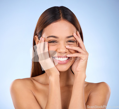 Image of Beauty, cosmetics and portrait of cheerful woman with hands on face in studio for skincare promo on blue background. Makeup, natural facial and hispanic model from Brazil for dermatology promotion.