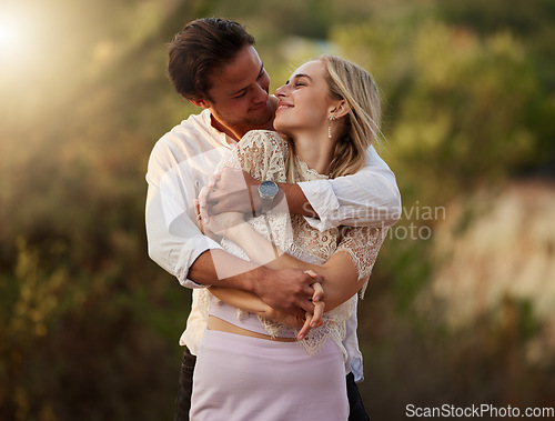 Image of Couple, love and hug outdoor at sunset for love, care and romance on date. Young man and woman together on valentines day with flare, peace and freedom in nature forest with trust, support and smile