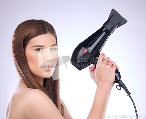 Image of Hair, dryer and portrait of woman in studio for beauty, grooming and heat styling on background. Young female model, haircare and tools for straight hairstyle, drying or salon appliance for treatment