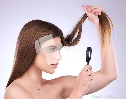 Image of Magnifier, haircare and woman with magnifying glass checking hair damage isolated in a studio white background. Beauty, treatment and sad female model doing hairstyle health inspection of growth