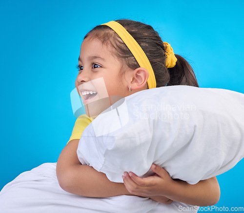 Image of Happy, cute and child with a pillow for sleep isolated on a blue background in a studio. Smile, excited and a young little girl thinking of sleeping, getting ready for a nap or rest on a backdrop