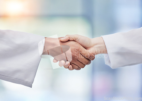 Image of Doctors, handshake and healthcare partnership in agreement, teamwork deal or collaboration. Medical professionals shaking hands in meeting, greeting and success of trust, thank you or consulting help