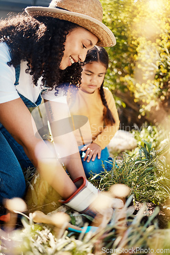 Image of Family, children or gardening with a woman and daughter planting plants in the backyard together. Nature, kids or landscaping with a mother and female child working in the garden during spring