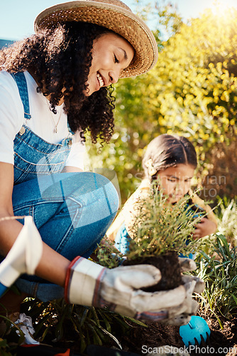 Image of Family, kids or gardening with a mother and daughter planting plants in the backyard together. Nature, children or landscaping with a woman and female child working in the garden during spring