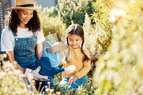 Image of Family, children or watering with a mother and daughter gardening together in the backyard. Plants, kids or landscaping with a woman and female child working in the garden during spring