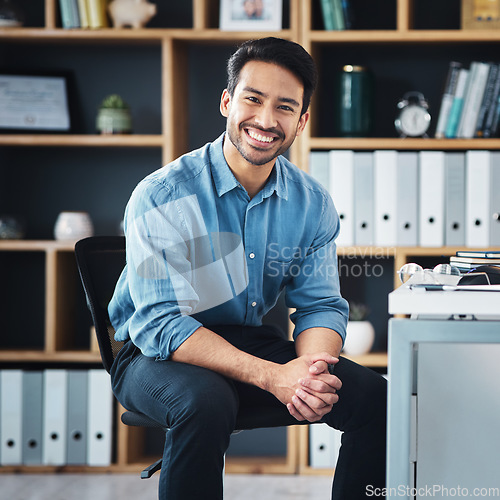 Image of Relax, break and portrait of businessman smile and sitting in startup company office excited for the future. Young, happy and professional man employee or worker feeling confident, proud